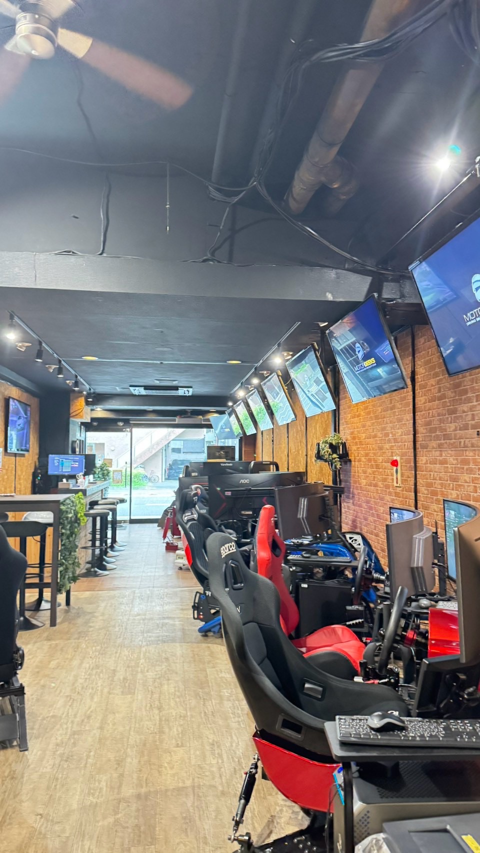 Drift simulator shop with racing seats, steering wheels and multiple screens